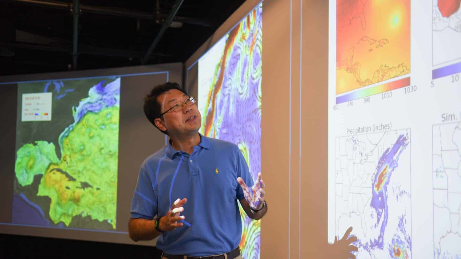 Ruoying He looks at ocean weather visualizations on large screens