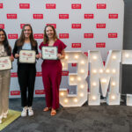 Alyssa Griffin with the other winners of the Three Minute Thesis challenge. A large white and illuminated 3-M-T stands behind them.