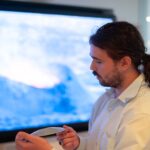 Aiden Nixon holds a 3D printed volcano and talks to visitors