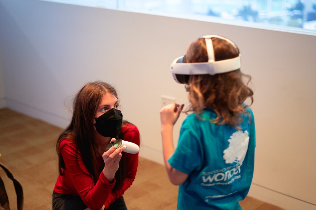 Professor Arianna Soldati assists a child putting on a VR headset