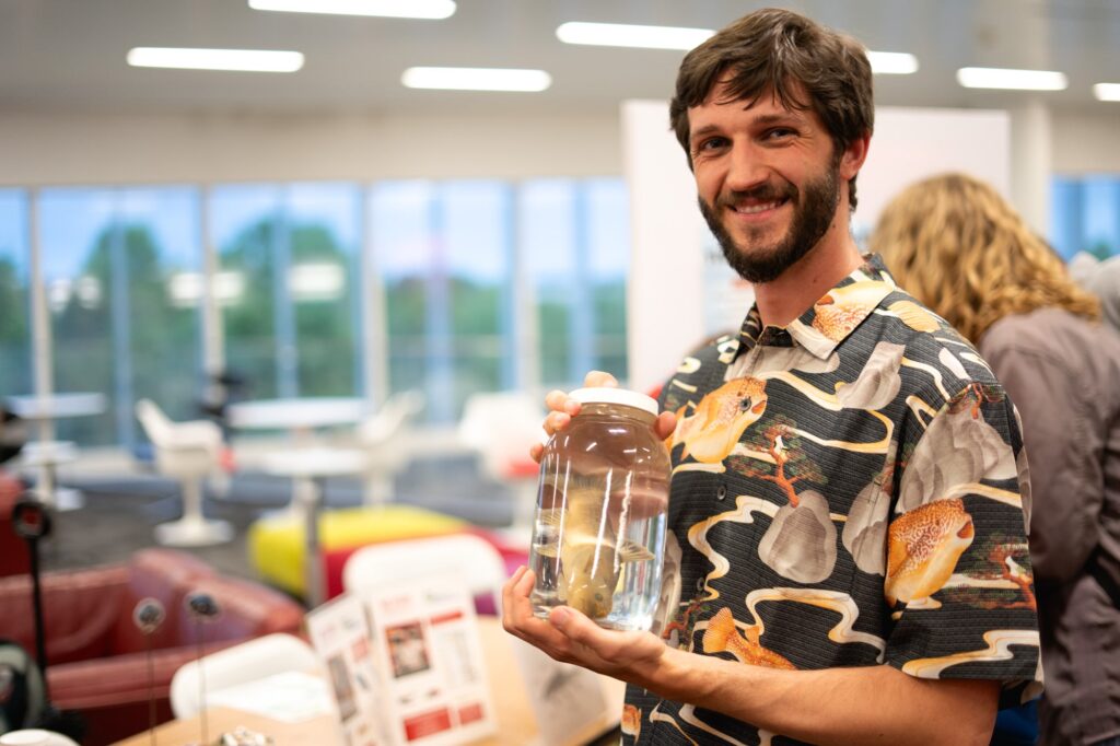Tyler Muller holds a preserved fish specimen in a jar