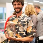 Tyler Muller holds a preserved fish specimen in a jar