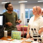 Chayse Jones and Lucy Roussa talk at their booth