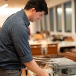 Camilo Rey-Sanchez places an item that looks like mud in a clear box to measure its greenhouse gas emissions