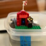 A lego pirate floats in a container with melting ice