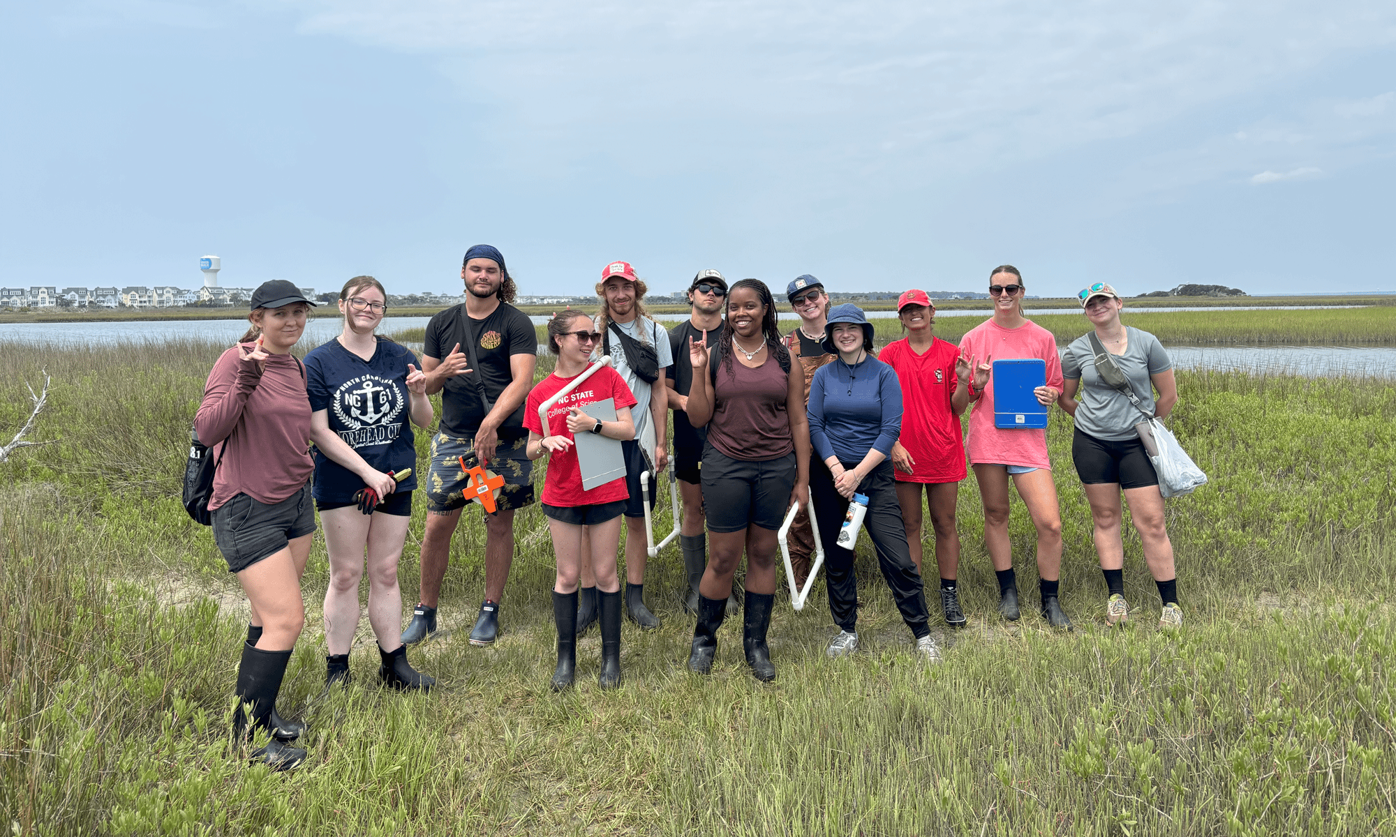 Students in the marine science field camp stand for a group photo in a salt marsh