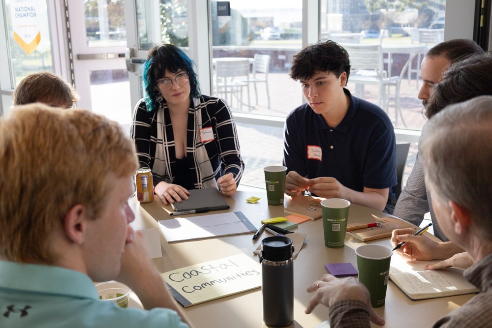 Students at the "coastal communities" table brainstorm solutions